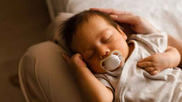 Baby sleeps on parent knees