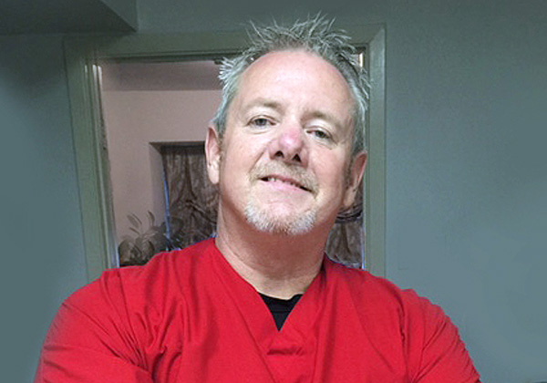 Man smiling in red shirt