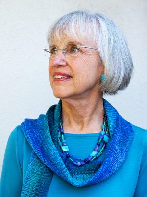 Woman in blue and gray hair looking into the distance