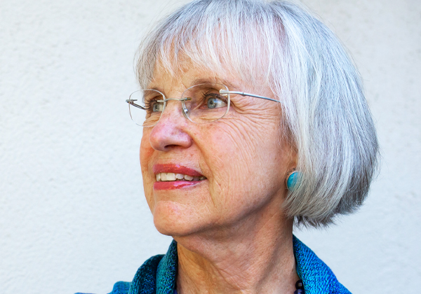 woman with glasses and gray hair looking into the distance