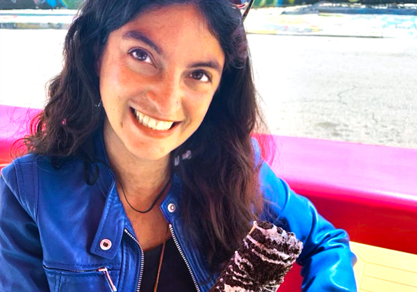 woman in blue jacket smiling and eating ice cream