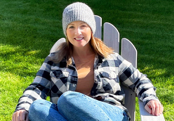 Woman sitting in chair outside with beanie hat and flannel on