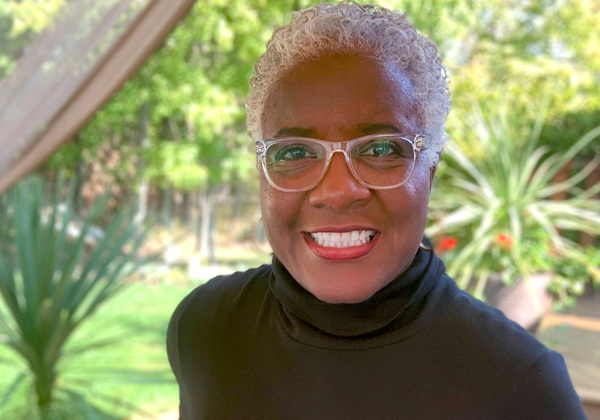 African American woman with glasses in black turtleneck