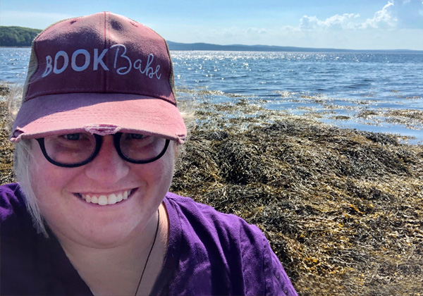Woman in hat in front of ocean