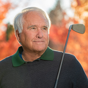 elderly gentleman with golf club looking into the distance
