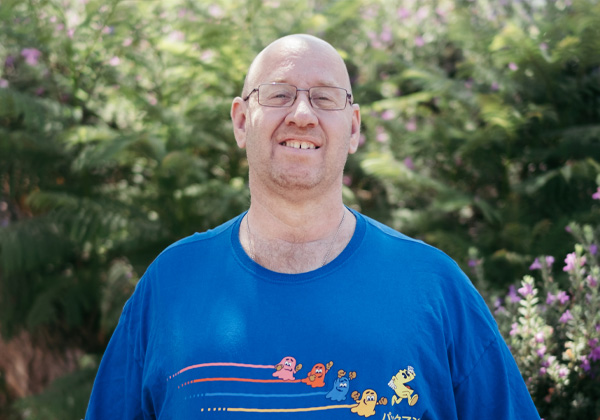 Man in blue shirt and glasses smiling at camera