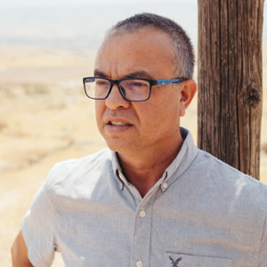 man with glasses in the desert looking into the distance