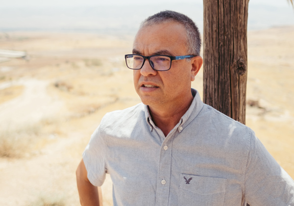 man with glasses in the desert looking into the distance