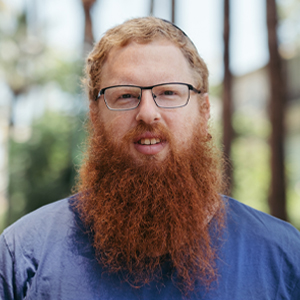 Red headed man with beard standing in the woods