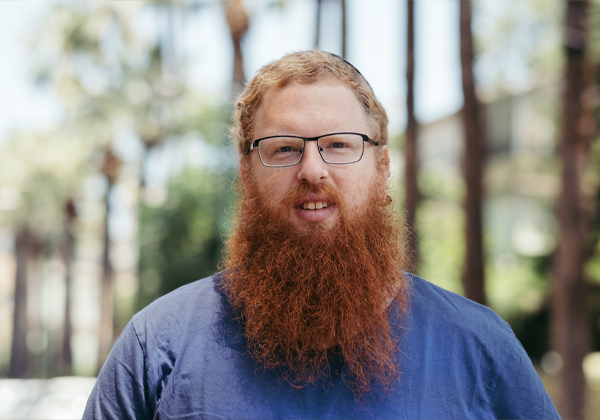 Red headed man with beard standing in the woods