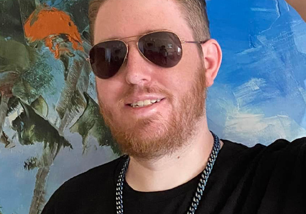 man with sunglasses and black shirt looking at camera