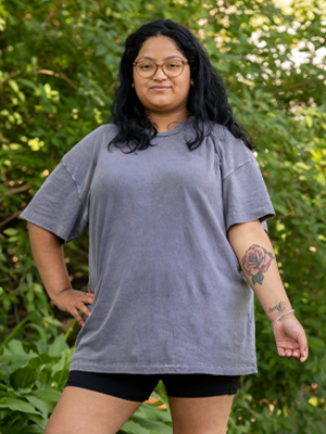 Woman proudly standing tall and showing tattoo on arm