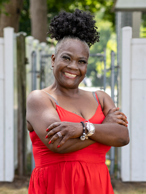Black woman in red dress smiling at camera