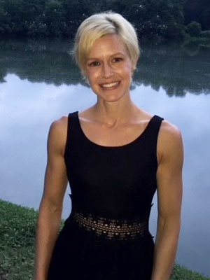 blonde woman in black tank top standing in front of water