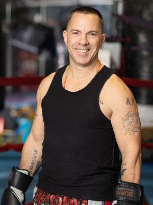 man in boxing ring with gloves on smiling