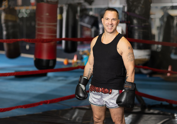 man in boxing ring with gloves on smiling